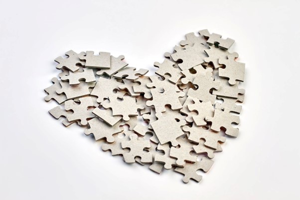 puzzle pieces layered and arranged in a heart shape